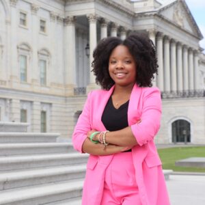 Woman stands arms folded on the steps of Capitol Hill
