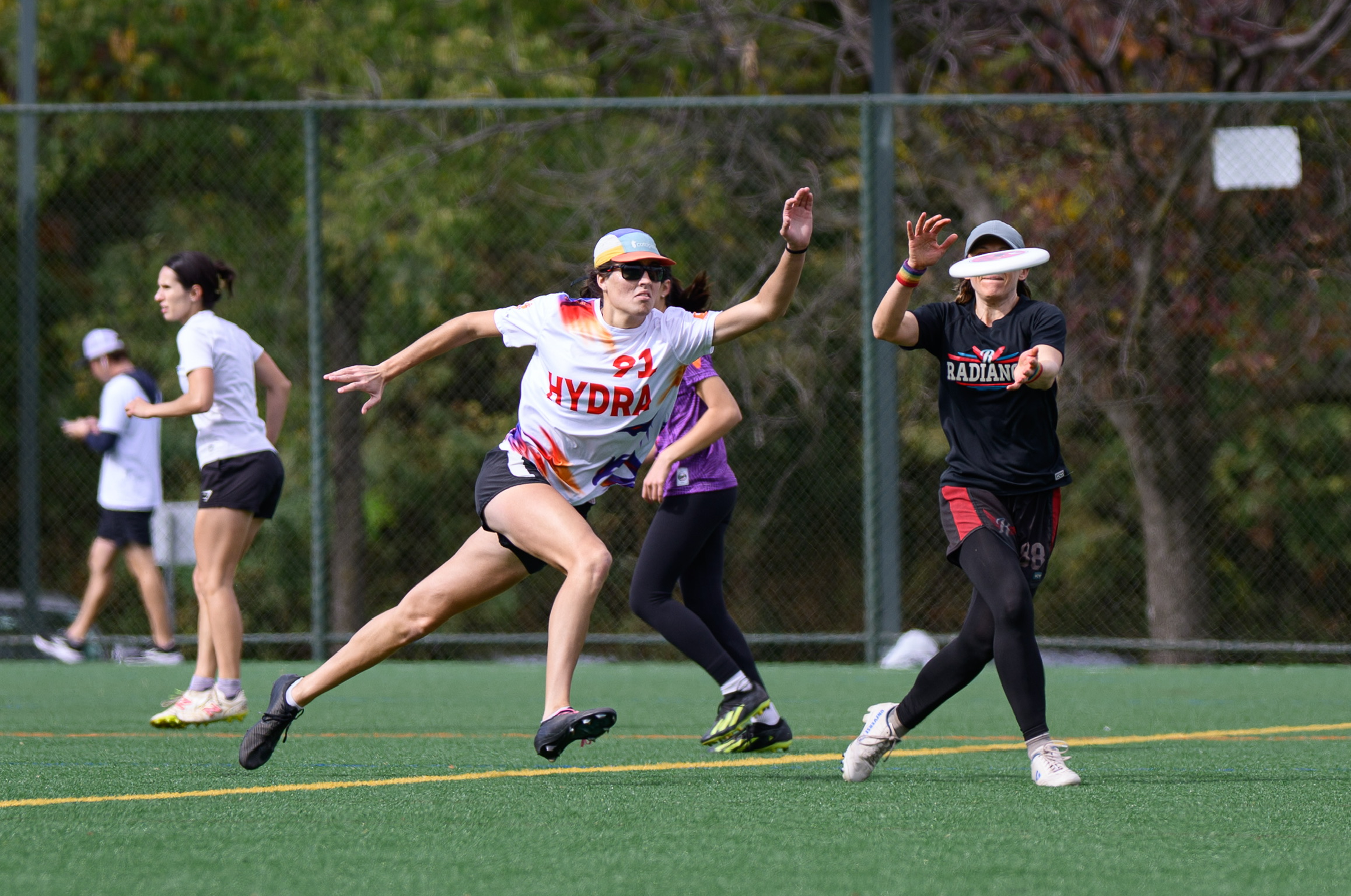 Ultimate frisbee team players on the field reaching for the disc