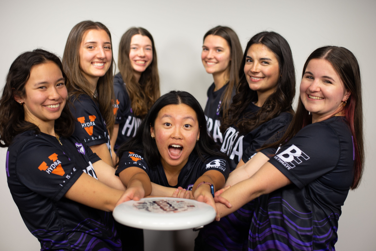 UVA's women's frisbee team pose for a picture holding a disc